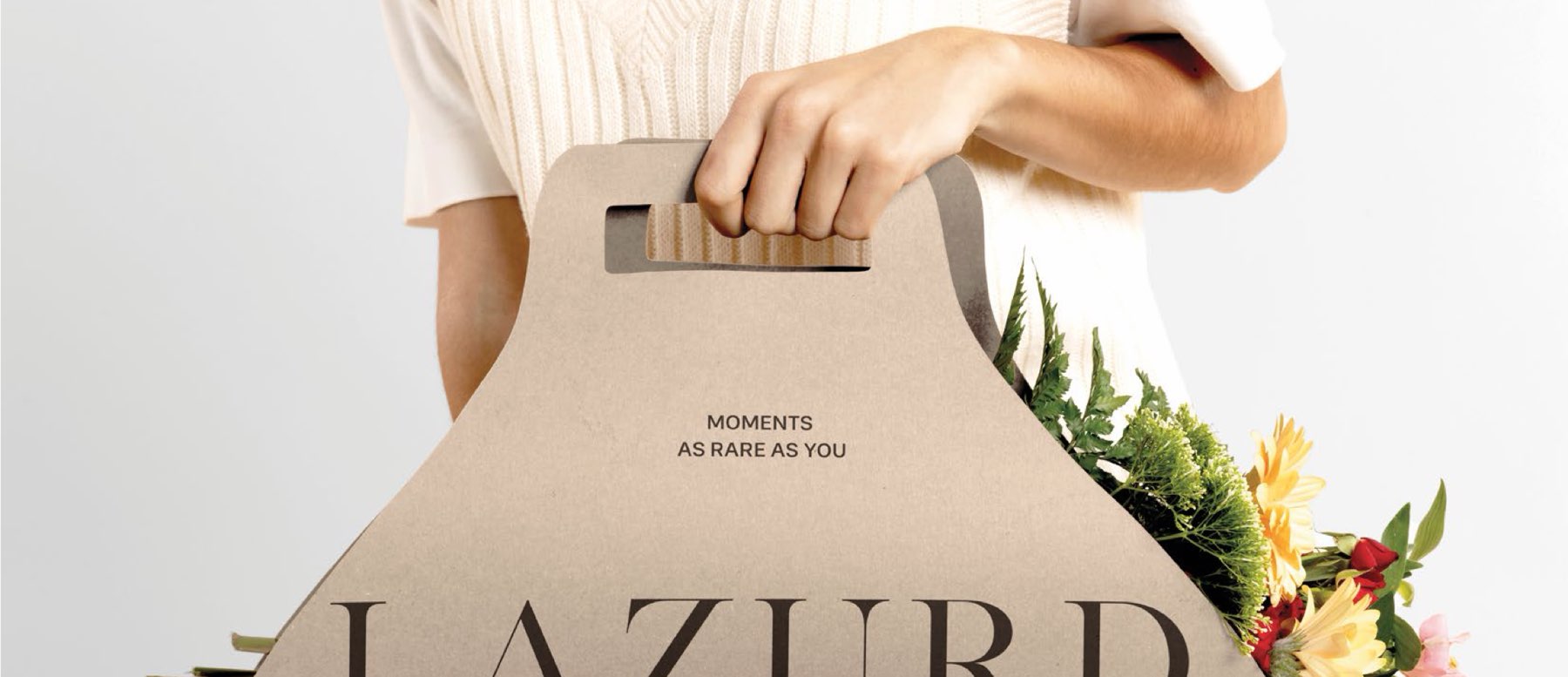 A Lazurd kraft gift bag held with fresh flowers