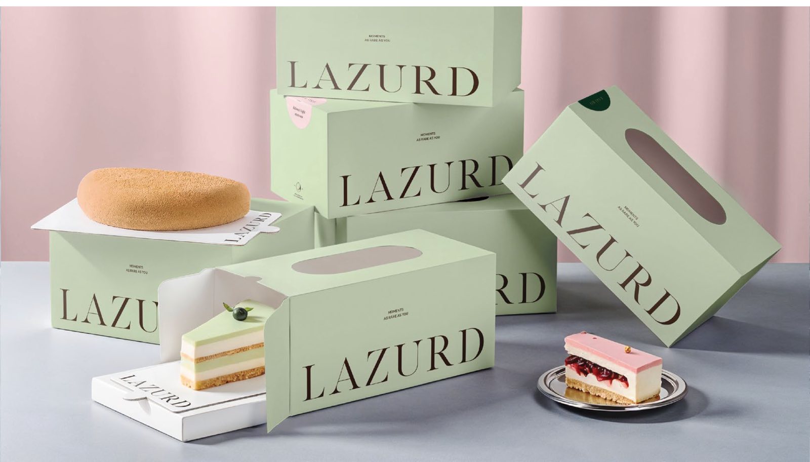 Lazurd cake boxes stacked against a rose curtain